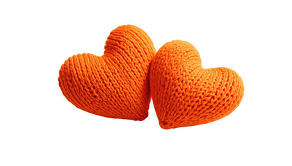 Two orange knitted hearts, close, against a stark black backdrop
