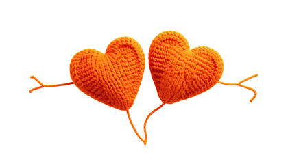 Two orange yarn hearts with yarn arms against black