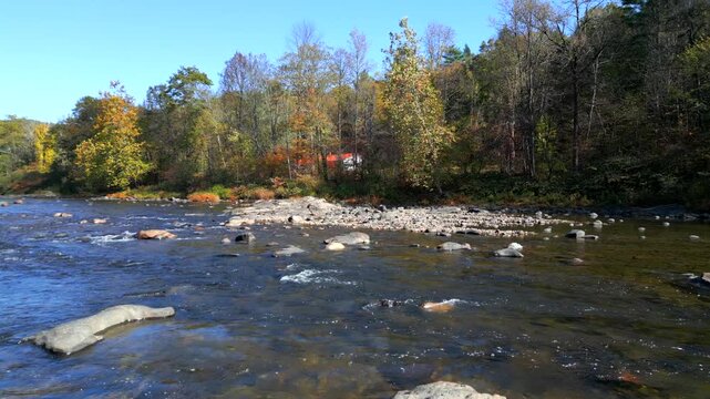 Aerial low flyover perpendicular to water flowing downstream, West River, Green Mountains Vermont USA