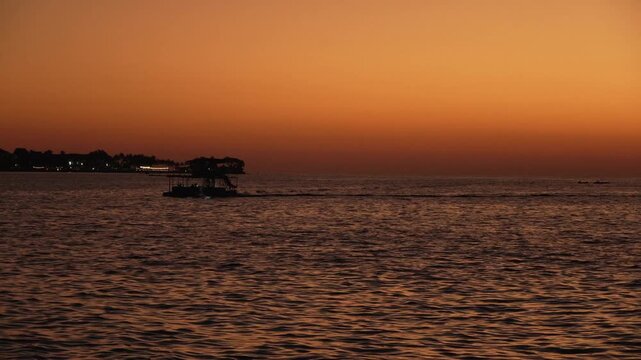 Beautiful stuning sunset,with nice city background,with boat and blue sea