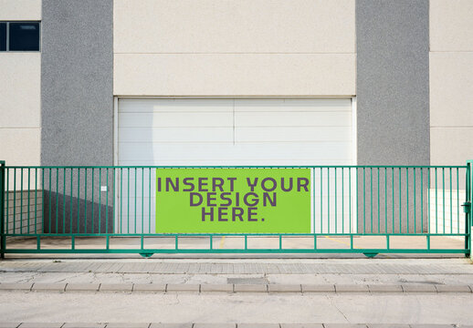 A green gate stands in front of a building with a blank space for design