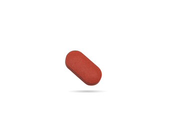 Red vitamin pill tablet flying on background