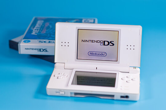 Fukuoka, Japan - november 4, 2025 : nintendo DS with various game cartridges isolated on blue background