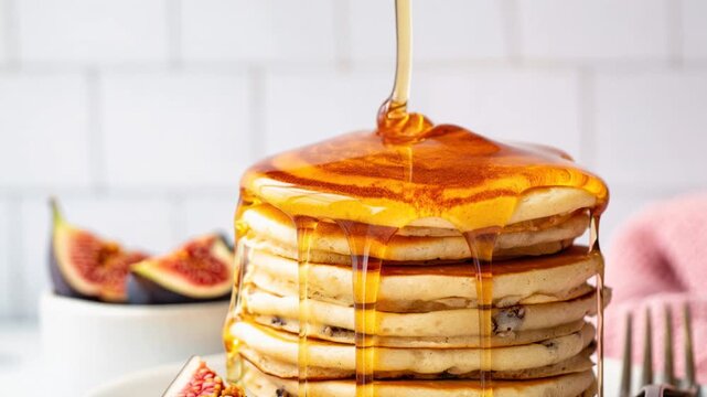 Close-up of golden honey slowly cascading over a stack of fluffy pancakes, evenly coating each layer and dripping down the edges, evoking a warm and appetizing feeling