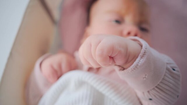 Close up of baby's tiny hand reaching out gently in soft pastel tones