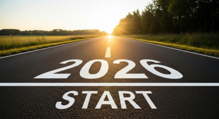 Empty straight asphalt road with the text 2026 START painted on the surface illuminated by the bright morning sun flare representing the beginning of the new year