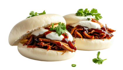 Two stuffed bao buns with sauce, cream, and greens on top
