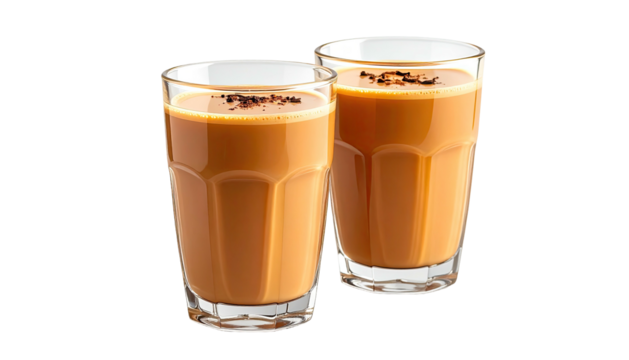 Two glasses of chai tea with sprinkled spice, cropped close