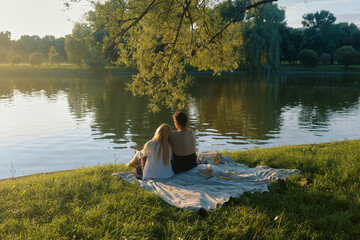 Enjoying a picnic by a tranquil pond in the golden light of late afternoon
