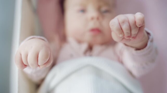 Close up of baby's tiny hand reaching out gently in soft pastel tones