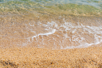 The water is clear and the sand is brown