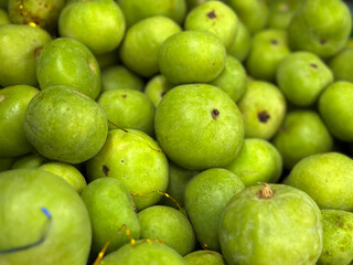 Close-up view of fresh green Tinda (Indian round gourd) piled together. Smooth, round vegetables with natural speckles, commonly used in Indian and Pakistani cooking.