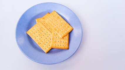Top view of cheese crackers in blue plate isolated on white background. Flat lay