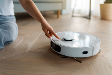 White robotic vacuum cleaner on wooden floor