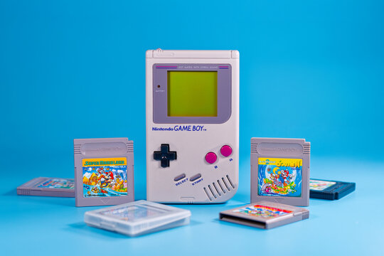 Fukuoka, Japan - november 4, 2025 : nintendo game boy with various hit game cartridges isolated on blue background