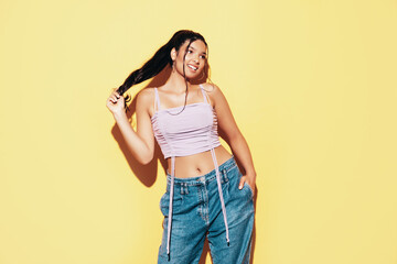 Young beautiful smiling female in trendy summer jeans and top clothes. Carefree woman posing near...