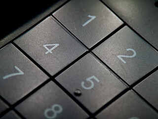 Textured gray keypad displaying numerical values with contrasting white font in an isometric view.