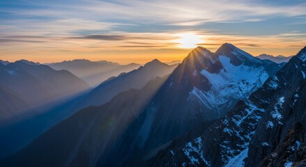 Majestic mountainous panorama with setting sun casting golden rays over snow-capped peaks