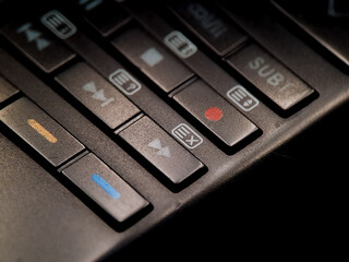Obraz premium Angled shot shows various control buttons with colored and labeled icons in dim lighting.