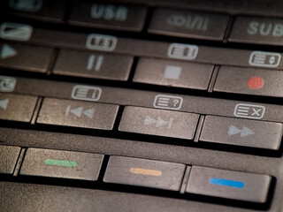 Control panel buttons featuring playback and recording symbols in an old device system.