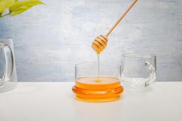 Honey background. Sweet honey in the glass jar. Light gray background.text.