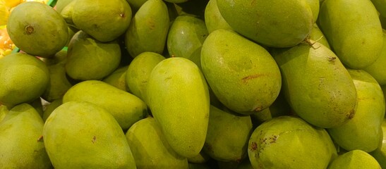 a collection of fresh mangoes neatly arranged in a supermarket