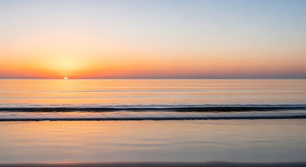 Fototapeta premium Sunset Over Calm Ocean with Soft Pastel Colors and Gentle Waves