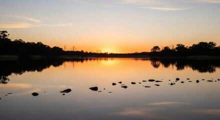 Serene sunset reflecting in still water, with silhouettes of trees on the horizon