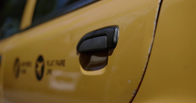 Closeup on hand opening and closing Taxi door in New York city