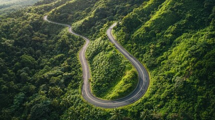A drone view of a joyride through winding mountain roads surrounded by lush greenery