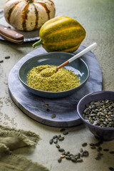 Pumpkin seed flour in a bowl with seeds, healthy food concept