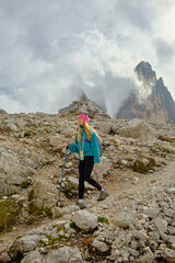 Hiker navigating rocky terrain in the Mountains during a cloudy day