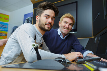 young man and manager sitting at desk in the office
