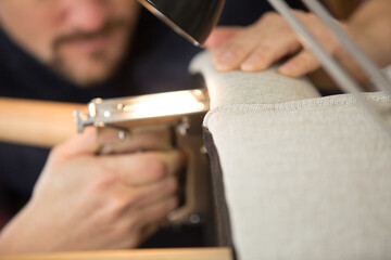 upholstery worker stapling furniture cover padding © auremar
