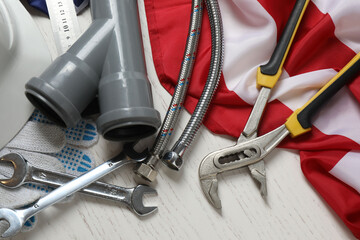 Image of work gloves, tools and American flag on wooden surface symbolizing Labor Day in the USA
