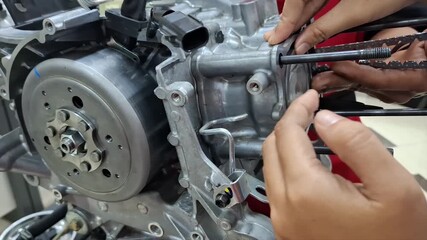 Mechanic Assembling Motorcycle Engine and Educational Cutaway Model