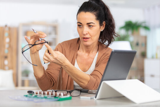 optician repairing spectacles with tool in optical store