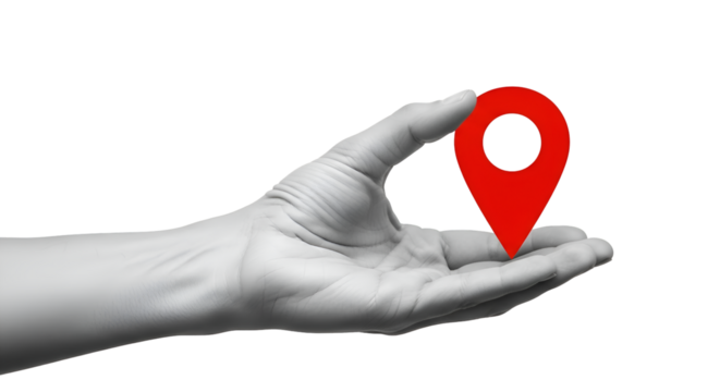 Red map pin location marker held in a grayscale human hand against black holding