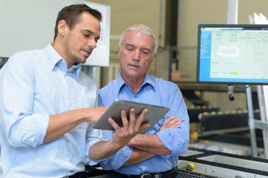 senior and young employees using tablet