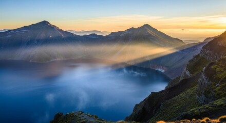 Scenic mountain range embracing a serene lake bathed in the warm glow of the rising sun