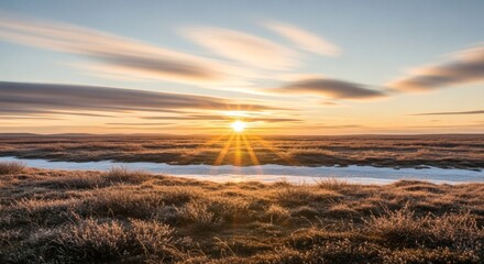Expansive landscape, vibrant sunrise casts golden light over icy terrain and distant horizon