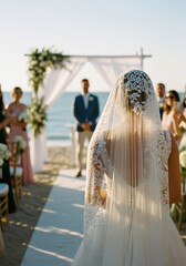 A bride in a white lace gown and veil stands on a sandy beach, facing a groom in a dark suit. Guests in pastel dresses watch the ceremony by the ocean.