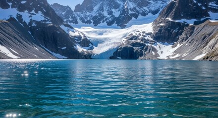 Stunning vista of a glacial lake, framed by majestic snow-capped mountains under a bright sky