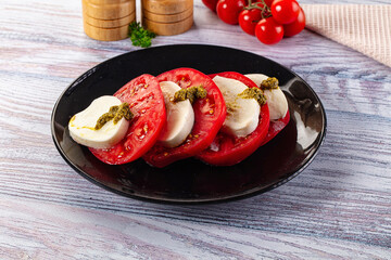 Italian Caprese salad with tomato, mozarella and pesto