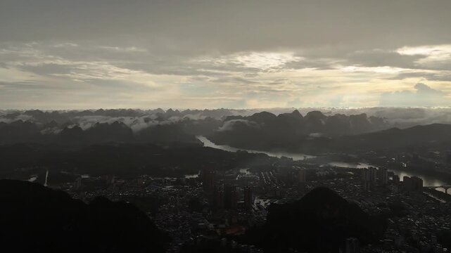 Nature Documentary: Sunshower Over Mountain Town with Golden Haze and Cloud Layers