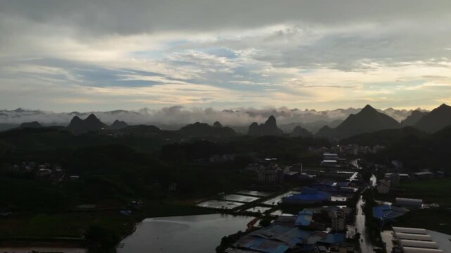 Golden Hour Sunshower Over Mountain City with Mist and Dramatic Sky, Aerial China