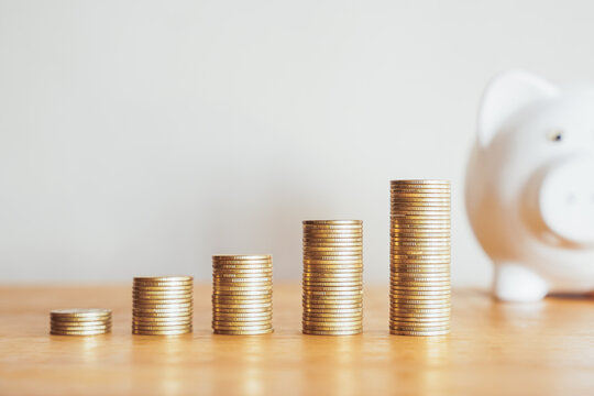 Piggy bank and a growing stack of gold coins symbolize savings, investment, and financial growth in banking and business