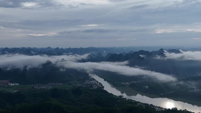 Drone Shot of Sunshower and Golden Rays Over Mountain City with Distant Mist, China