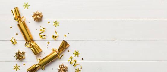 Christmas crackers with shiny confetti on color background, top view, copy space