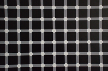 Abstract geometric pattern featuring a black background with intersecting gray lines and white dots, creating an optical illusion effect. The grid design produces a dynamic visual experience.